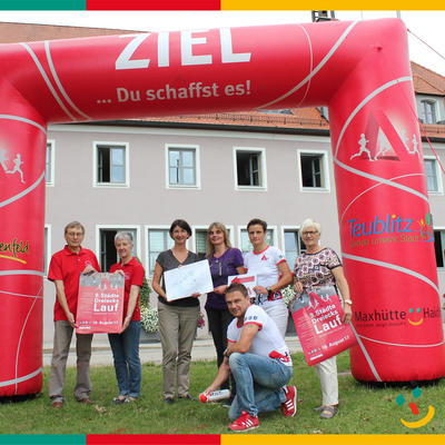 Bild vergr��ern: Das Bild zeigt Erste B�rgermeisterin Dr. Susanne Plank (3te von links) mit Sabine Eichinger, Hauptverantwortliche des Laufes (2te von rechts) mit den Mitstreitern des FC Maxh�tte-Haidhof und den Kommunen im Zieleinlauf in Maxh�tte-Haidhof am Rathaus. Markus Schomburg war bereits unterwegs und markierte die Strecke.