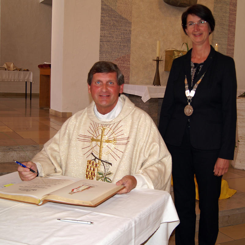 Pfarrer Peter Häusler und Bürgermeisterin Dr. Susanne Plank beim Eintrag ins Goldene Buch. 