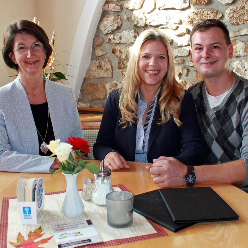 Stadlhof Stüberl wiedereröffnet: Das Bild zeigt Erste Bürgermeisterin Dr. Susanne Plank (links) zusammen mit den jungen Wirtsleuten Stefanie und Jürgen Meier im Stadlhof Stüberl.  