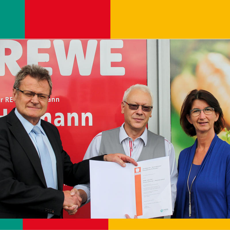 HBE-Bezirksgeschäftsführer Josef Kellermann (links) überreicht im Beisein von 1. Bürgermeisterin Dr. Susanne Plank an REWE-Markt Inhaber Hermann (Mitte) die Auszeichung.