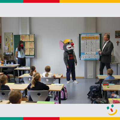 Bild vergrößern: Die MAXI-Maus besucht zusammen mit Erstem Bürgermeister Rudolf Seidl die ersten Klassen in der Maximiliangrundschule in Maxhütte-Haidhof