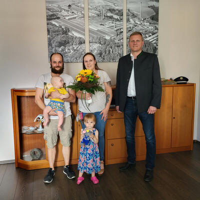 Bild vergrößern: Erster Bürgermeister Seidl (rechts) überreichte an Lisa Schwinghoff (Mitte) einen Blumenstrauß zur Begrüßung als 12.000ste Einwohnerin