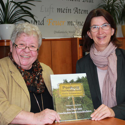 Bild vergr��ern: Autorin Christine Obermeier (links) �berreicht B�rgermeisterin Dr. Susanne Plank ihr erstes Exemplar der Ortschronik Ponholz.