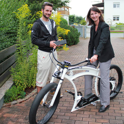 Bild vergr��ern: T�ftler und Maschinenbauingenieur Hadrien Dorfmann stellt B�rgermeisterin Dr. Susanne Plank sein neuestes Elektrofahrrad vor.